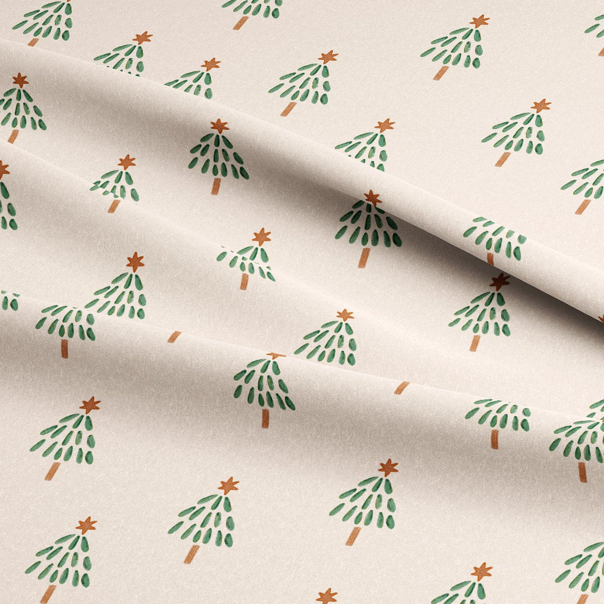 A close-up of a cream-colored fabric with a repeating pattern of small green Christmas trees with orange star toppers, draped with soft folds.