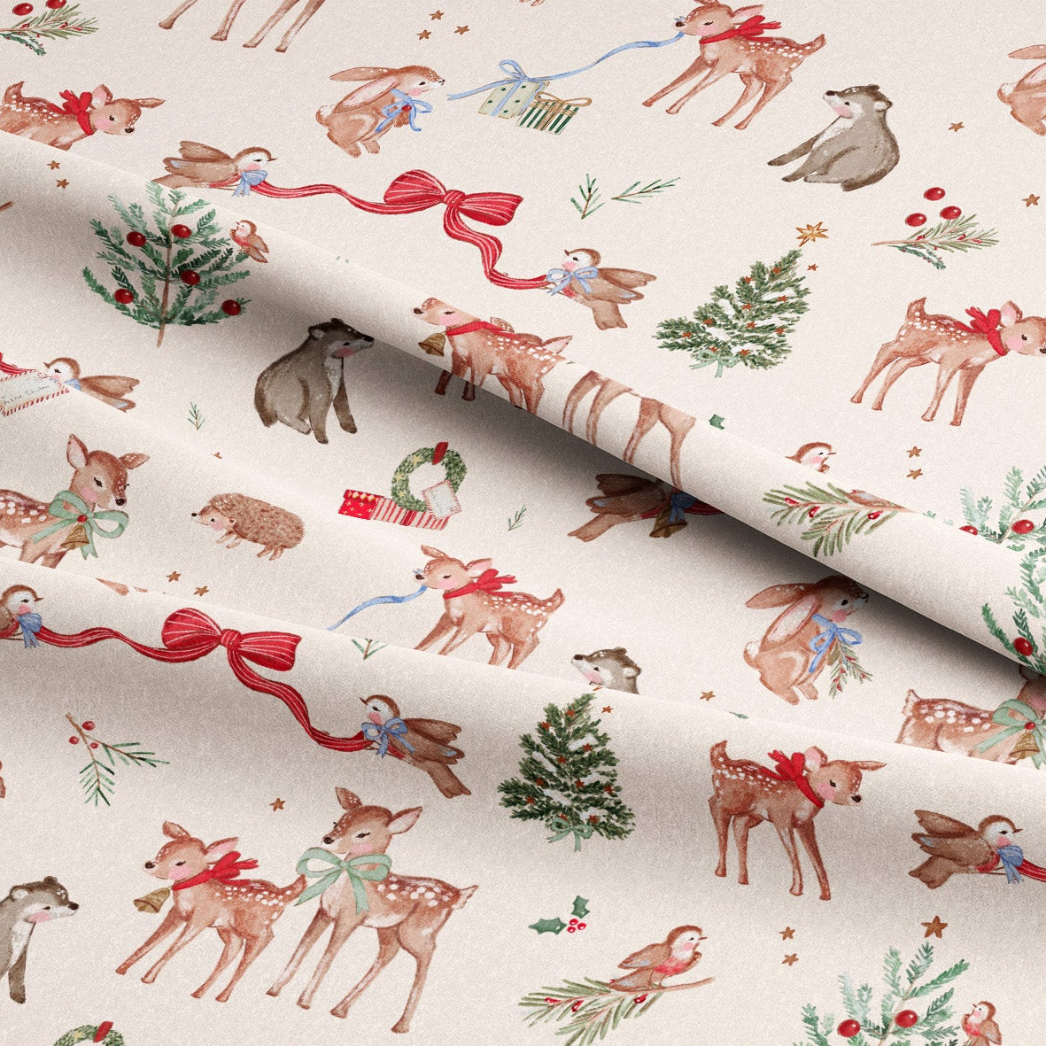 A close-up of cream-colored fabric with a festive Christmas print featuring brown deer, red bows, green holly, birds, and small holiday motifs, with the fabric folded diagonally.