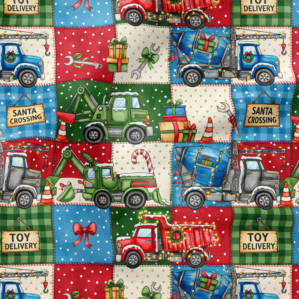 A repeating holiday-themed patchwork pattern featuring colorful toy delivery trucks, gift boxes, candy canes, snowflakes, and text labels such as 'Santa Crossing' and 'Toy Delivery' on red, green, blue, cream, and white squares.