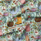 Patterned fabric with teapots, watering cans, and floral elements on a green background