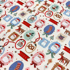 A close-up of a Christmas-themed fabric featuring a repeating pattern of Santa Claus, reindeer, stockings, ornaments, and banners in red, blue, green, brown, and beige.