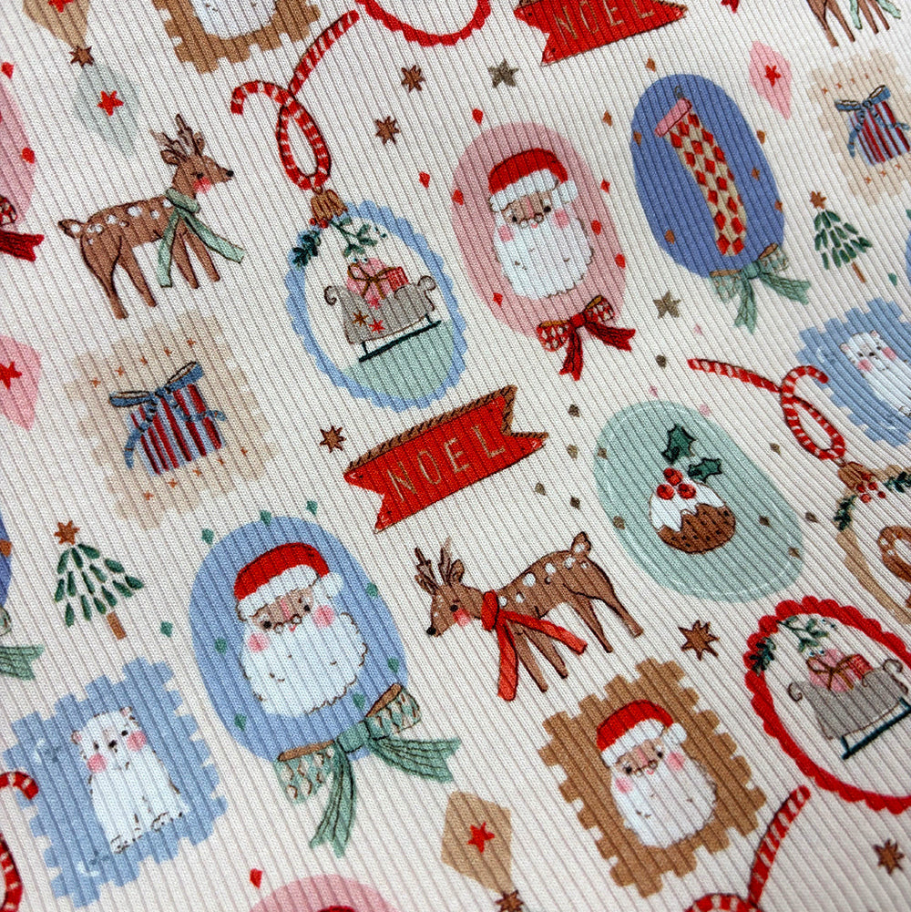 Close-up of a ribbed fabric with a festive Christmas print featuring Santa Claus, reindeer, ornaments, stars, and red banners reading 'MEL' on an off-white background.