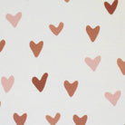 Close-up of beige fabric with pink and brown hearts