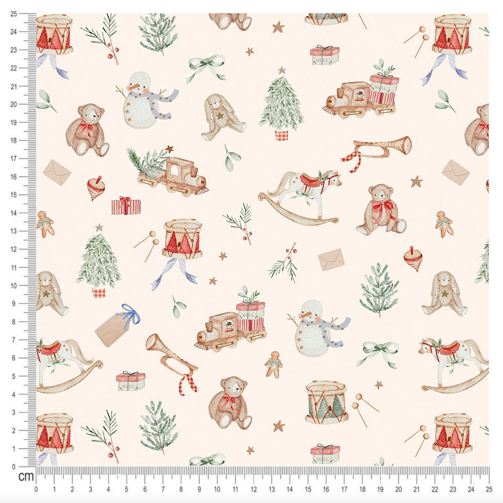 A repeating Christmas-themed pattern on a cream background, featuring teddy bears, snowman, rocking horses, Christmas trees, drums, toys, and small gifts. The print is shown with a measurement ruler along the left and bottom edges in centimeters.