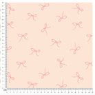 Close-up of pink bow print on soft fabric with measurement grid