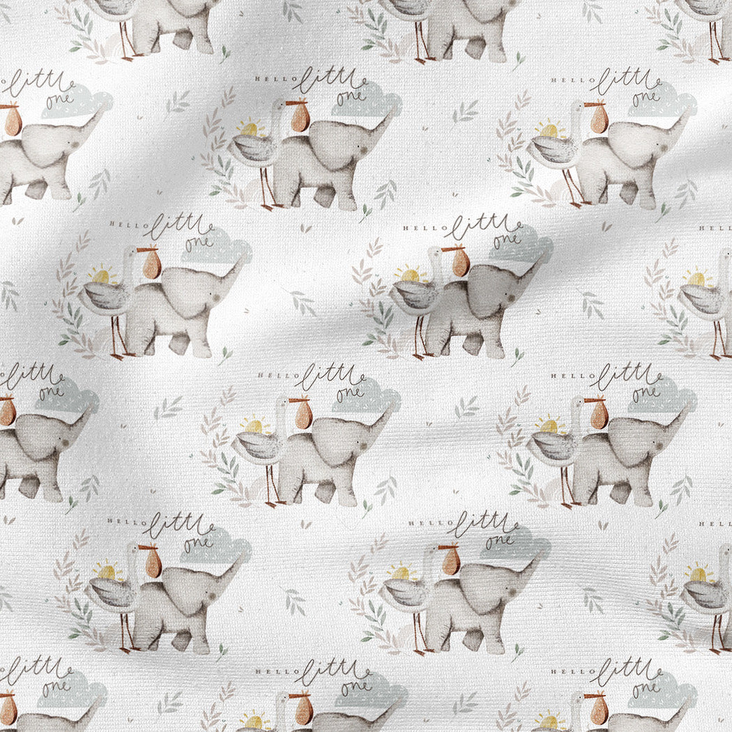 A close-up of a white fabric with a repeating pattern of small elephants carrying baskets, with soft gray shadows across the surface.