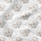 A close-up of a white fabric with a repeating pattern of small elephants carrying baskets, with soft gray shadows across the surface.