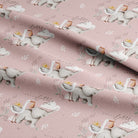 Pink fabric with a repeating pattern of white storks carrying baskets, small gray elephants, and delicate leafy branches, with the words 'little one' in script.