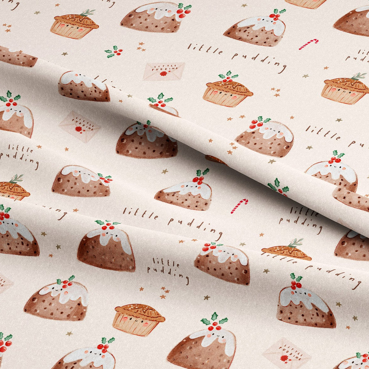 A close-up of patterned fabric with a repeating print of Christmas puddings, cupcakes, candy canes, holly, and small text reading 'little pudding' on a warm off-white background.