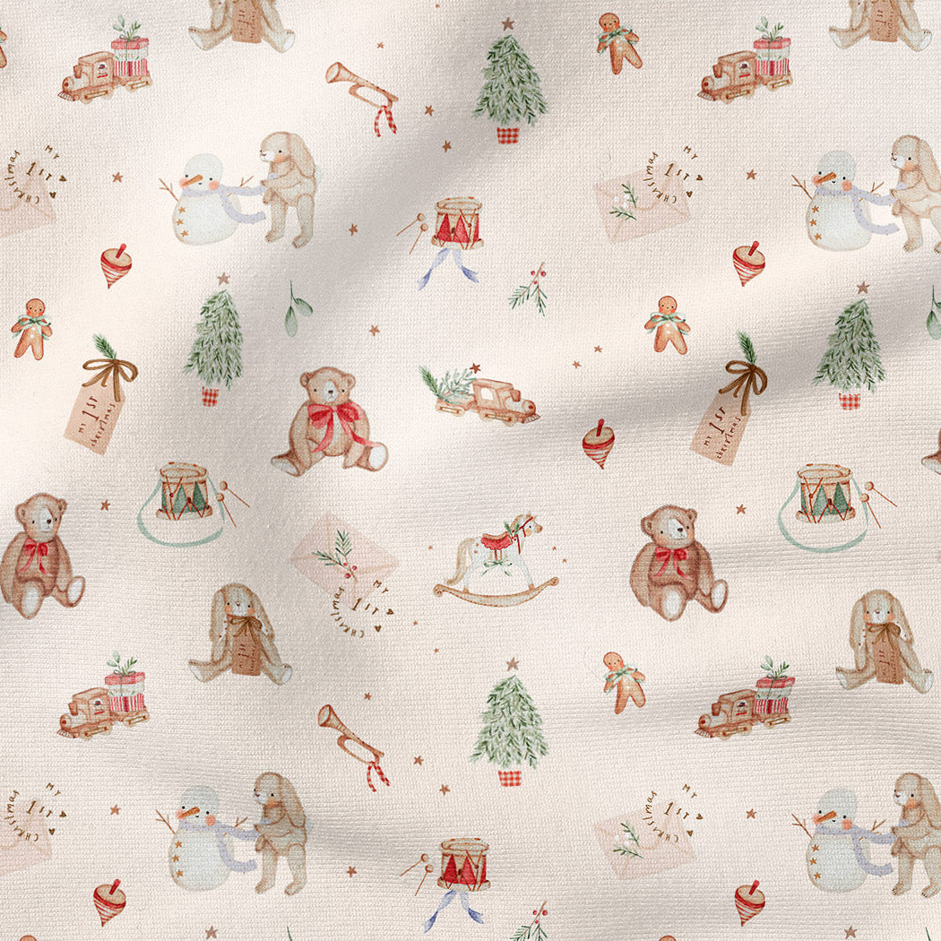 A close-up of a cream-colored fabric with a repeating Christmas teddy bear pattern, featuring soft watercolor illustrations of bears, trees, gingerbread men, and snowman motifs.