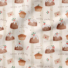A close-up of a fabric or wallpaper pattern featuring illustrated Christmas puddings, cupcakes, candy canes, and the words 'little pudding' on a warm cream background.
