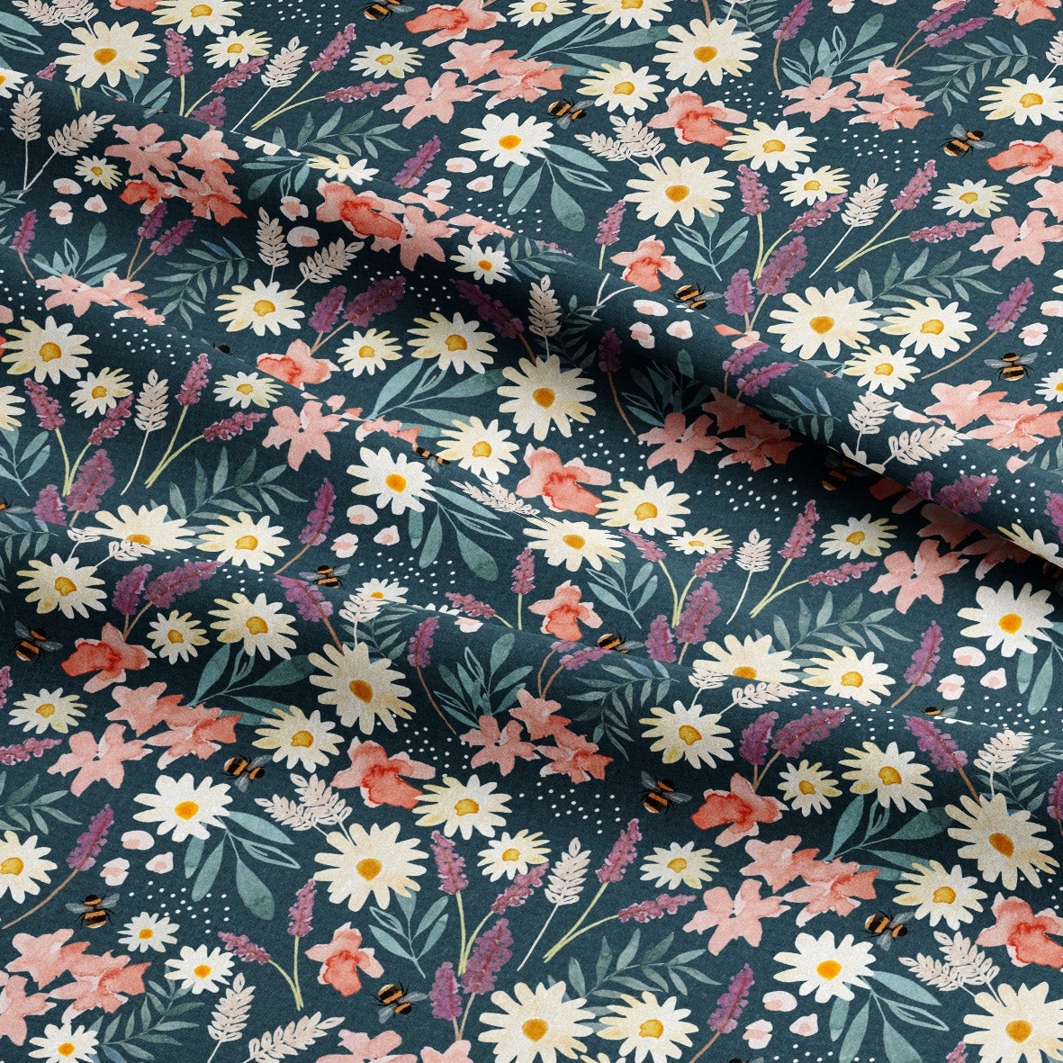 A close-up of a draped fabric with a dense floral print featuring white daisies, pink and peach flowers, and green leaves on a dark teal background.