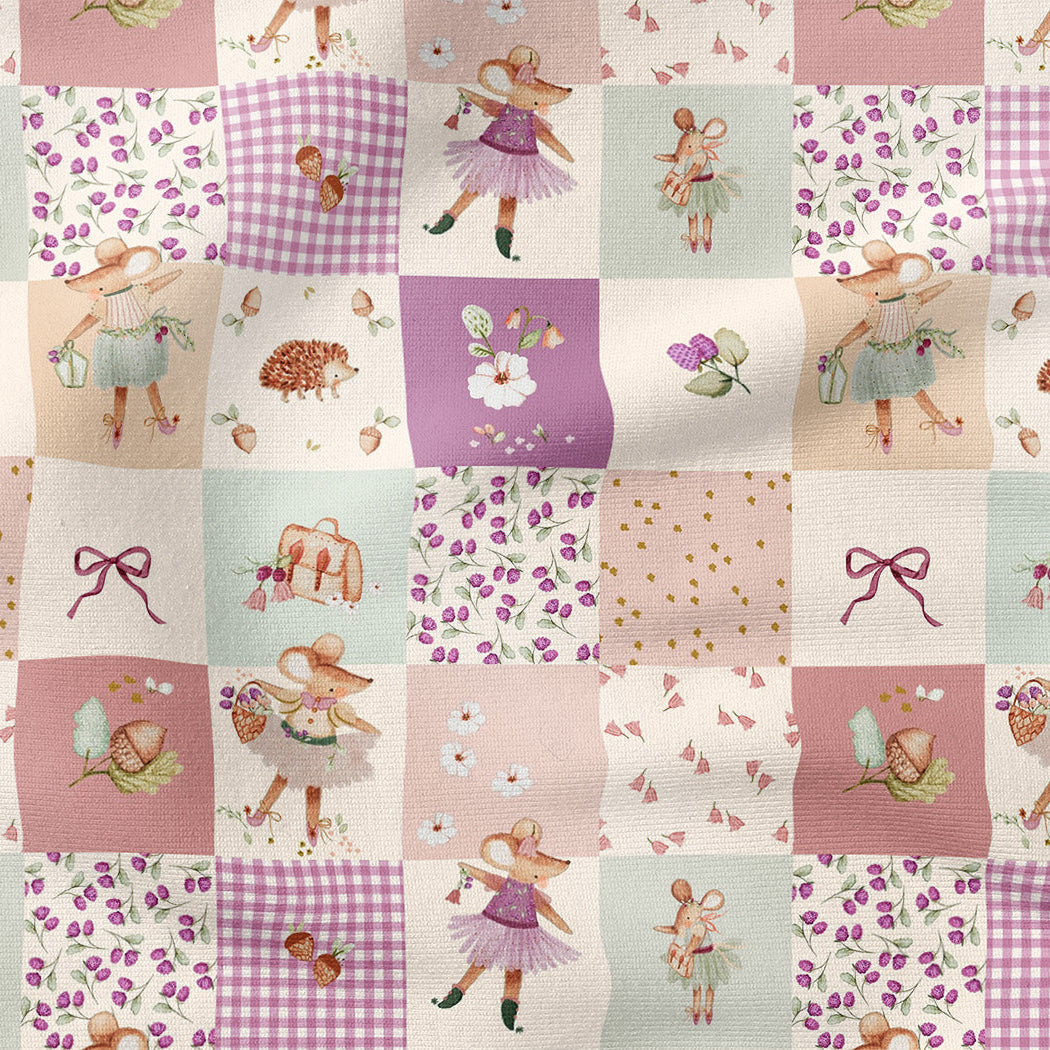 A patchwork fabric design featuring a whimsical fairy-themed pattern with various illustrated squares in pastel pink, purple, and cream tones, including fairies, flowers, gingham, bows, and small animals.
