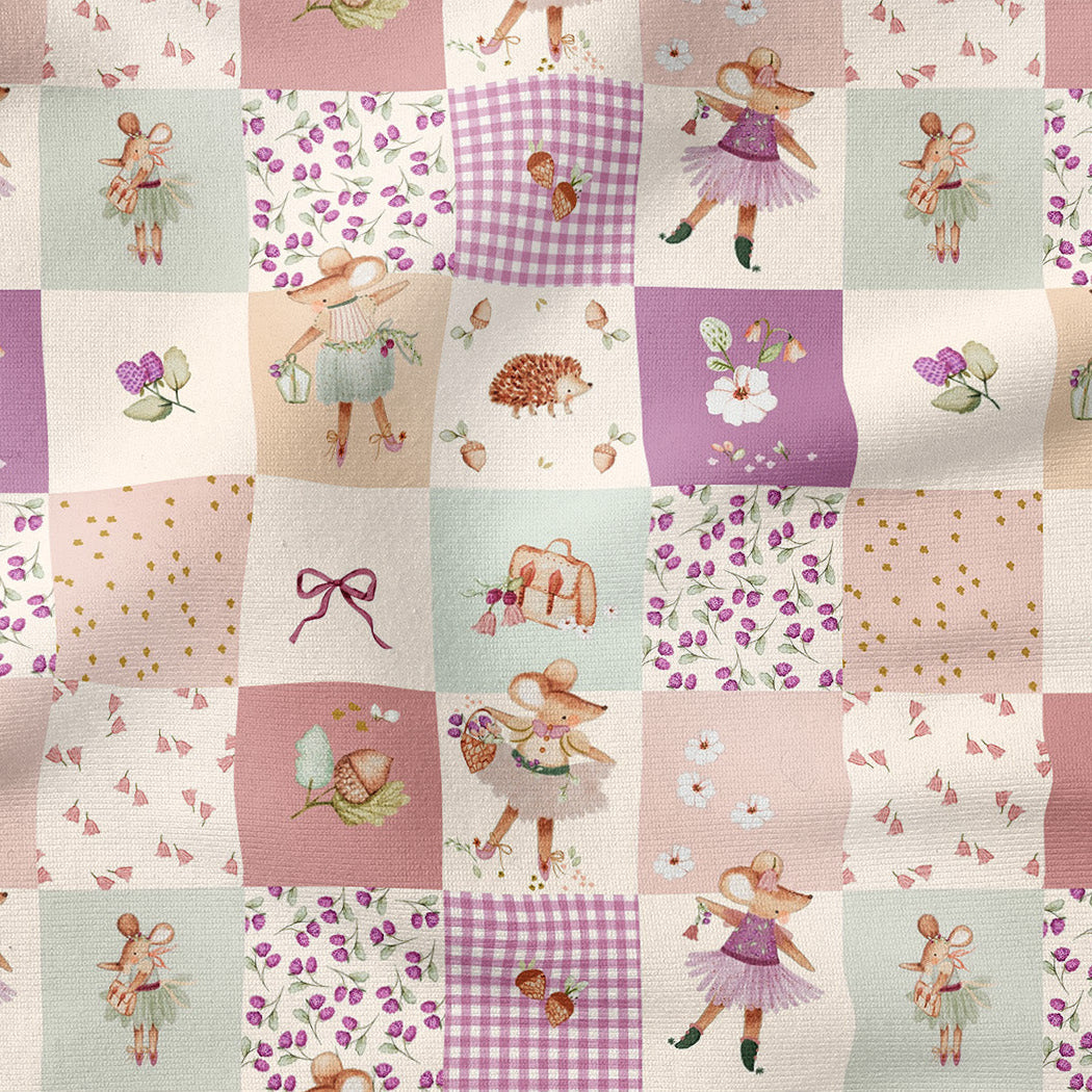 A patchwork fabric design featuring a whimsical fairy-themed pattern with various illustrated squares in pastel pink, purple, and cream tones, including fairies, flowers, gingham, bows, and small animals.