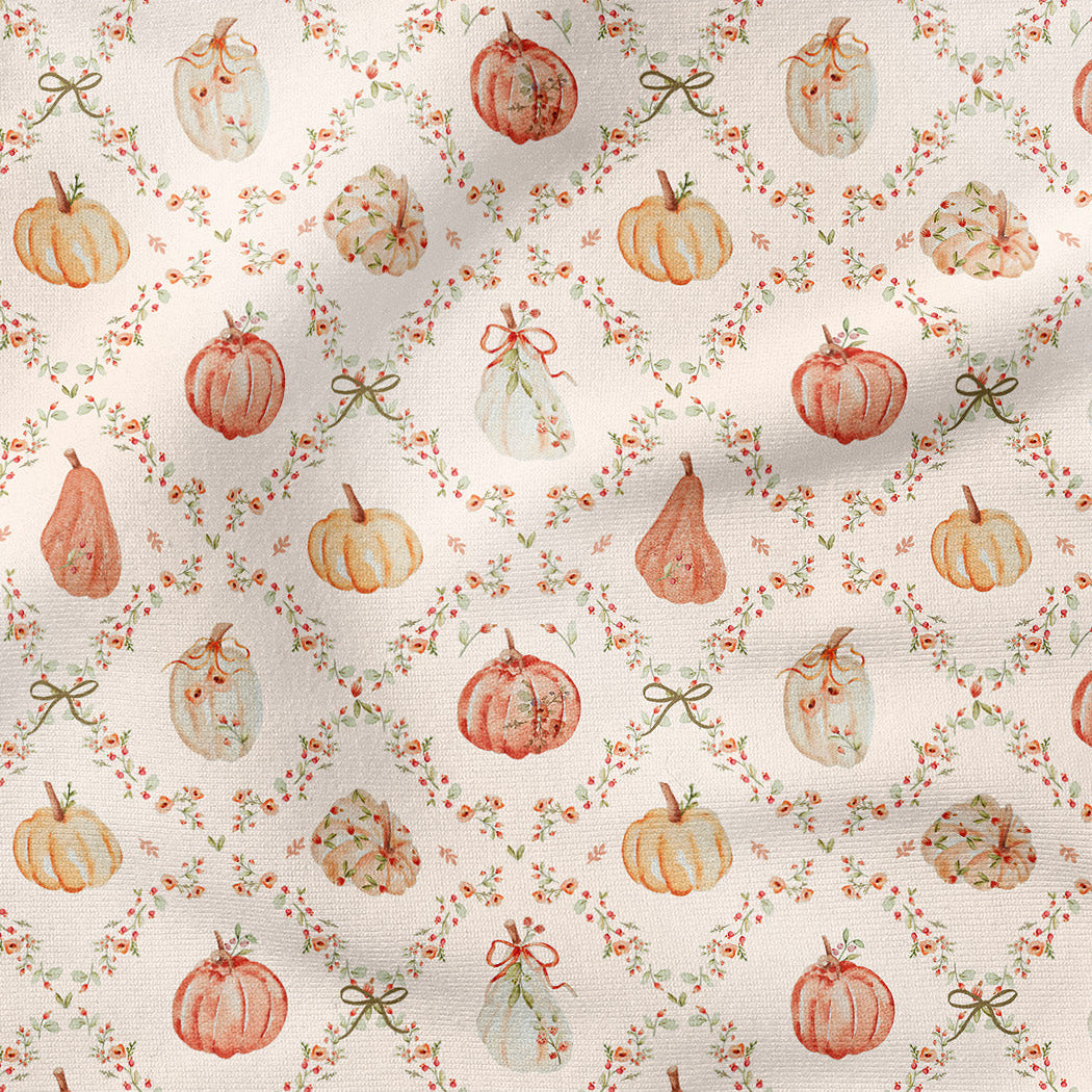 A repeating fabric pattern featuring watercolor-style pumpkins and pears in muted orange, peach, cream, and olive tones, arranged in a diamond lattice with small floral garlands and bows on a warm off-white background.