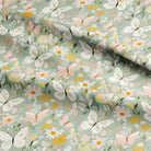 Fabric with a pattern of butterflies and flowers on a light green background