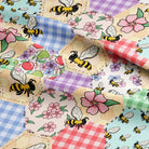 Fabric with bees, flowers, and checkered patterns in a patchwork design.