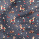 A close-up of a fabric pattern featuring vintage Christmas toys and candy cane motifs on a dark slate blue background.