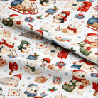 White fabric with a festive Christmas pattern featuring polar bears, penguins, snowman figures, mailboxes, gifts, and snowflakes in red, green, blue, and beige tones.
